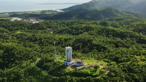 aerial orbit of a lone pagasa doppler radar station atop lush mountain overlooking tropical island at bato, catanduanes, philippines