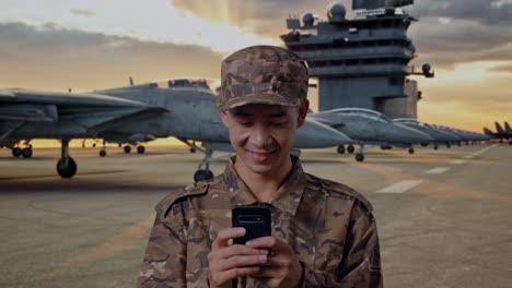 soldier on aircraft carrier using smartphone