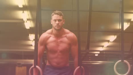 caucasian young man excising with resistance bands in gym with bokeh effect