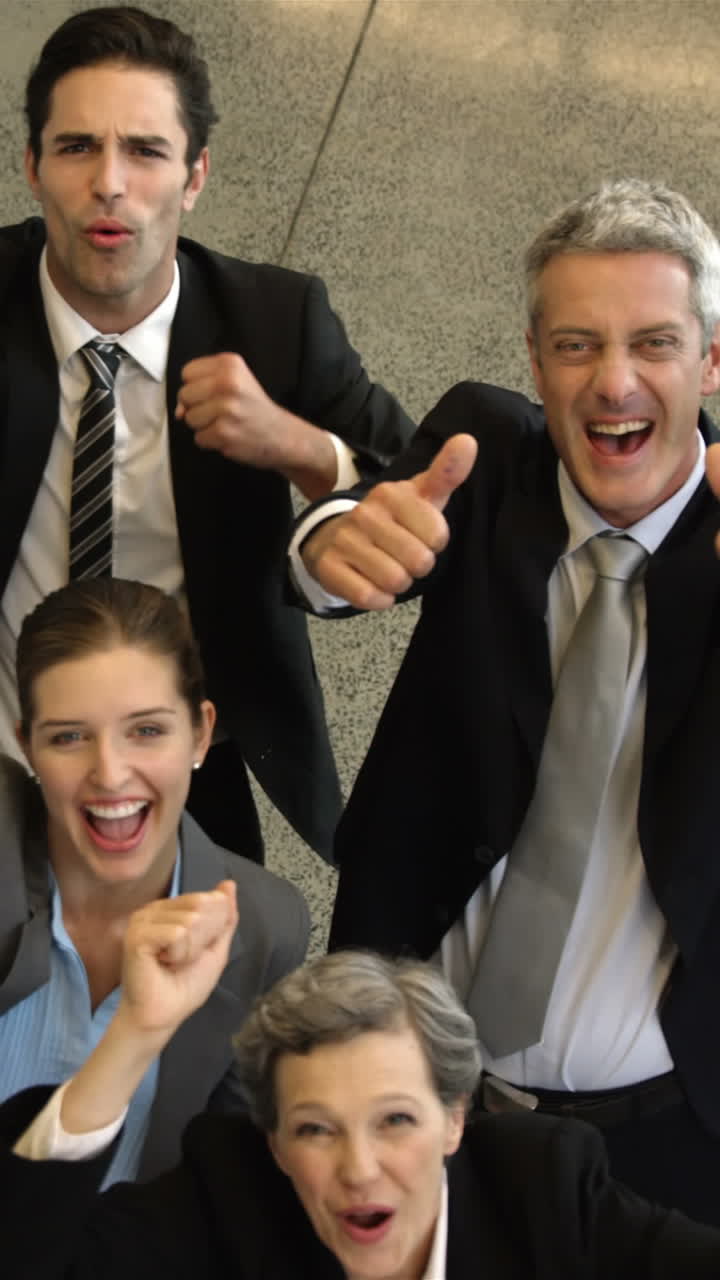 Business people cheering with thumbs up