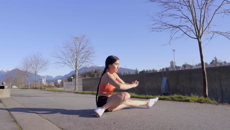 Joven-Mujer-Atlética-Flexible-Haciendo-Ejercicio-En-Cuclillas-Con-División-Lateral