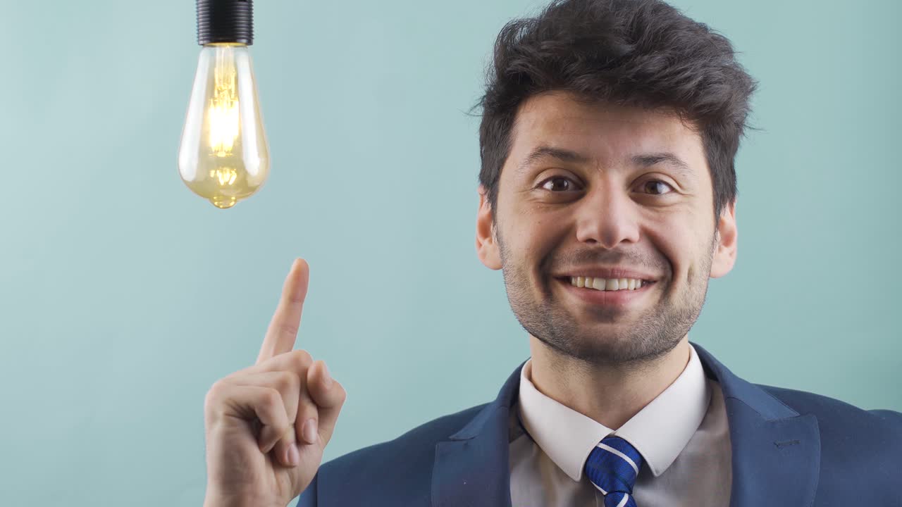 cuando una idea viene a la mente, la lámpara de la idea se enciende junto al hombre de negocios.