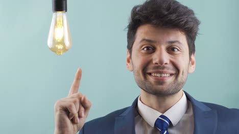 cuando una idea viene a la mente, la lámpara de la idea se enciende junto al hombre de negocios.