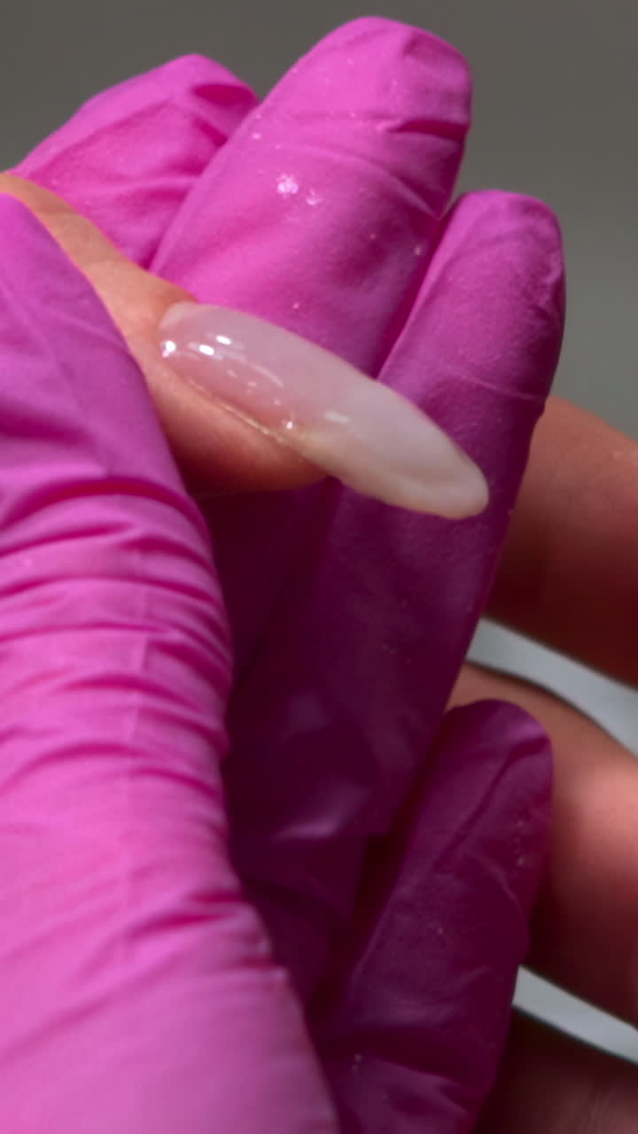 Close-up of Nail Technician Applying Gel Polish to Fingernail