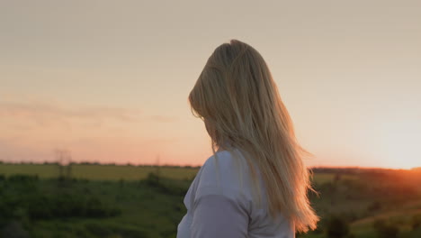 Frau-Spielt-Bei-Sonnenuntergang-Mit-Ihren-Langen-Haaren