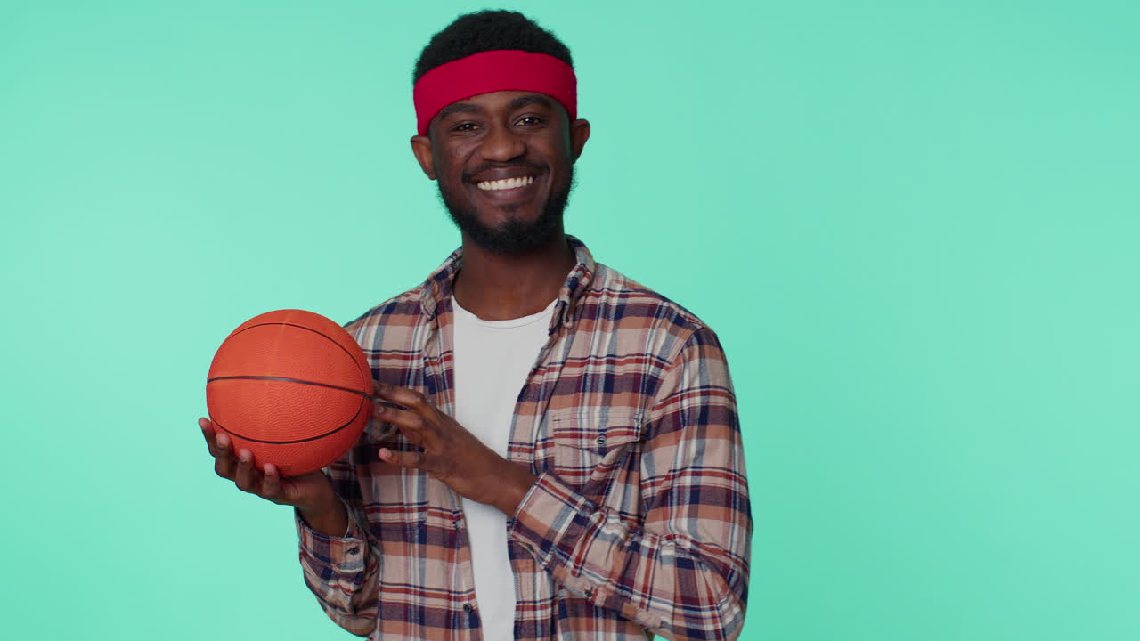 Bearded smiling african american young man basketball sport fan holding ball looking at camera