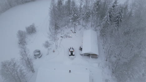 aerial circle view of tractor plows snow in a home backyard