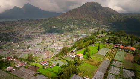 Flying-over-rural-landscape-near-Mount-Batur-or-Gunung-Batur-active-volcano-on-Bali-island,-Indonesia