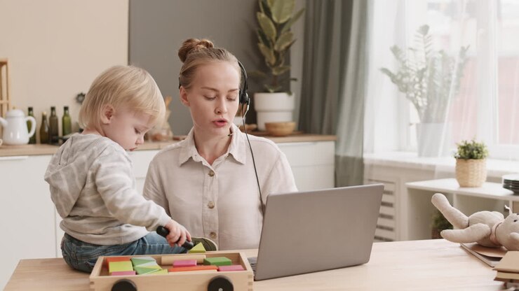 Mother Working and Toddler Sitting on Desk
