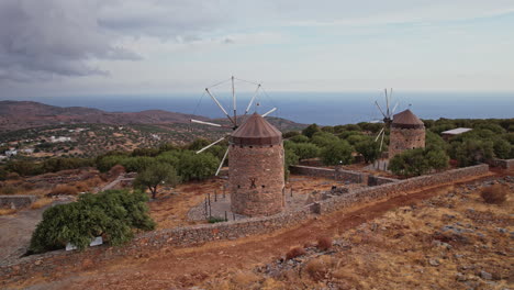 ancient windmills overlooking the ocean on a greek island at dusk