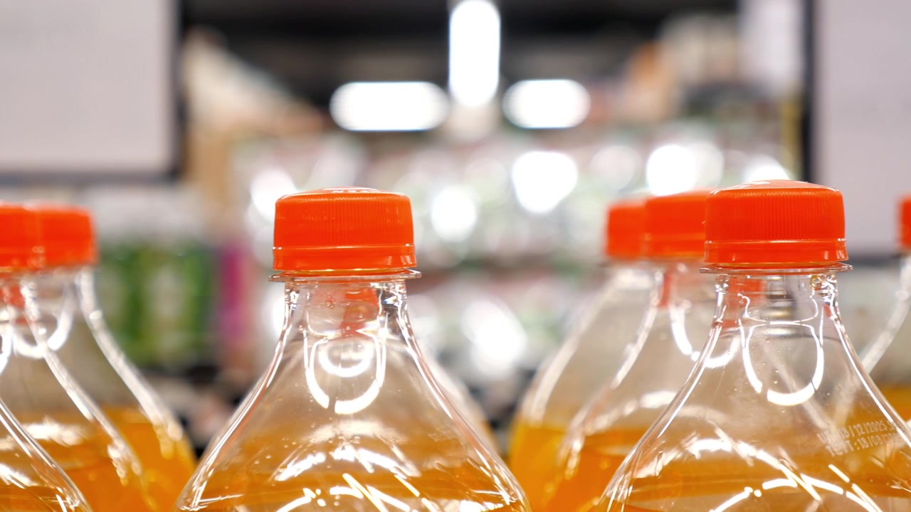 Rows of Orange Soda Bottles on Supermarket Shelf
