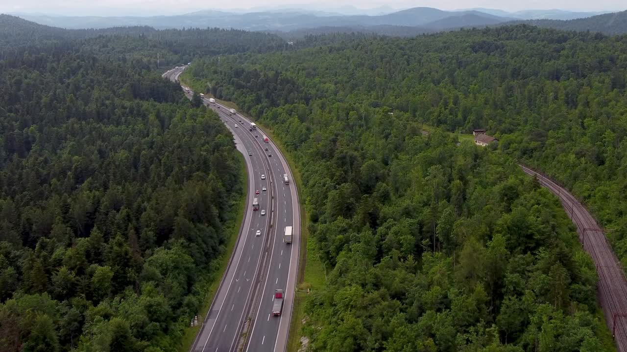 좋은 교통 흐름과 철도와 레일 바로  ⁇ 에 있는 유럽 2차선 고속도로와 드론에서 국가 도로를 둘러싼 녹색 벨트