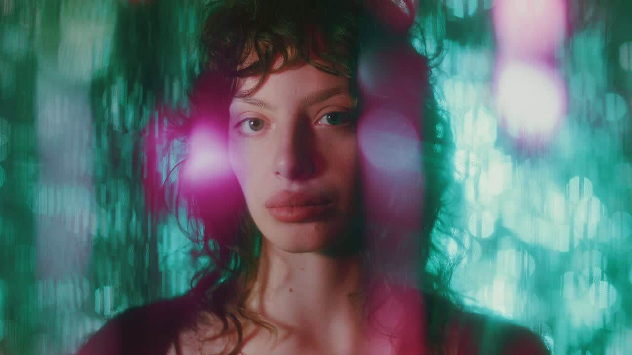 Portrait of Young Woman Standing among Glowing Bokeh Lights