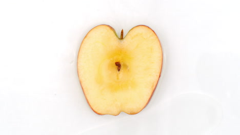 on a white background sliced apple slices are sprinkled with water