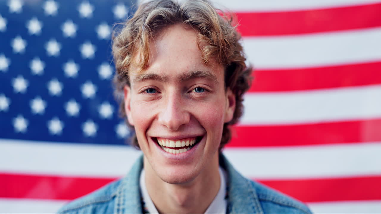 Man i jeansjacka framför amerikansk flagga