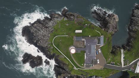 top down aerial drone view of solitary lighthouse overlooking the north atlantic ocean