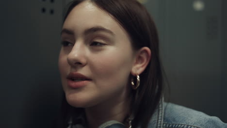 Closeup-attractive-girl-talking-in-school-hall.-Portrait-student-with-headphones