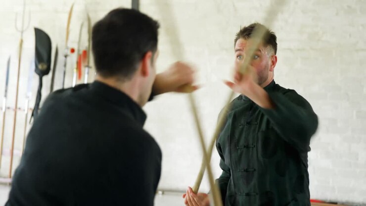 Combattenti di Kung fu che praticano arti marziali con un bastone a frusta 4k