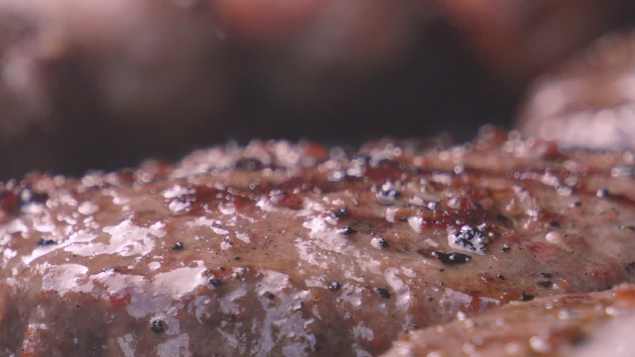 Close Up Details of Texture on Beef Burgers with Pepper Seasoning with Heat Distortion from Hot BBQ with Juices Reflecting as Patty Gently Cooks. High Protein Summer Outdoor Food.