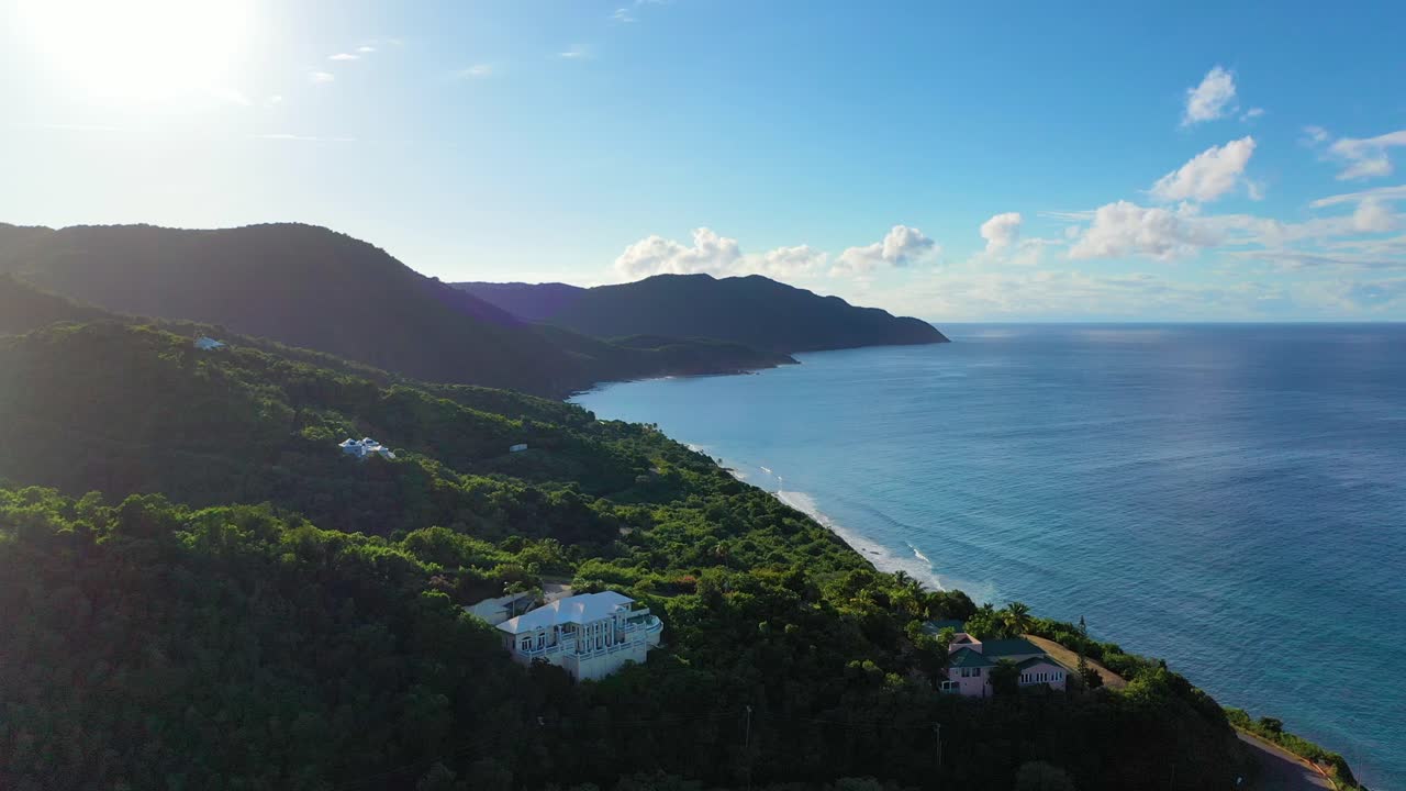 Elite vacation escapes are hidden along the forested coast of St. Croix, USVI, seen in this midday drone shot where calm Caribbean waters meet the elegance of secluded island living