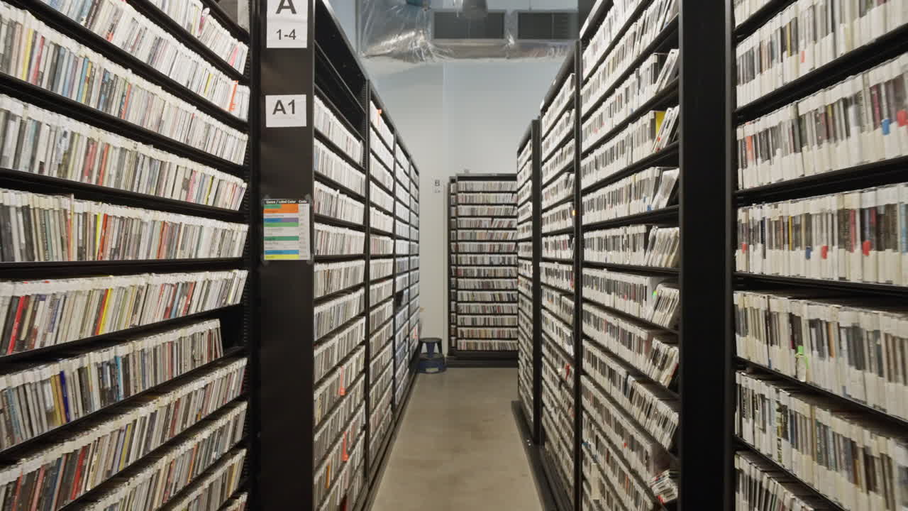 Records archive at KEXP in Seattle, Washington, USA. Vinyl collection stored on shelves with curated catalogs, showcasing music preservation, radio history and media culture in a studio