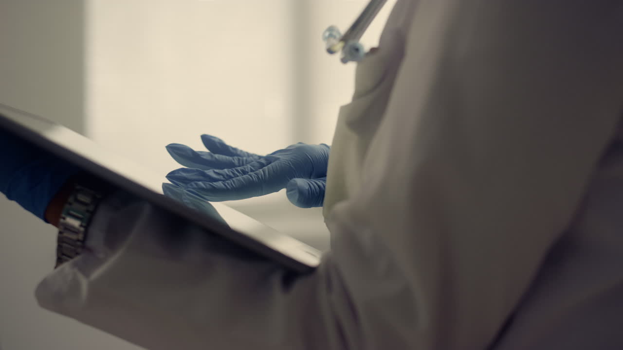 Mani del medico che toccano lo schermo del tablet, primo piano. Medico sconosciuto che tiene un tablet.