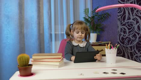 Child-schoolgirl-learning-lessons,-distance-education-at-home-sitting-at-table-using-laptop-computer