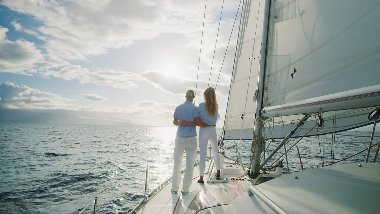 una pareja navegando hacia la puesta de sol.