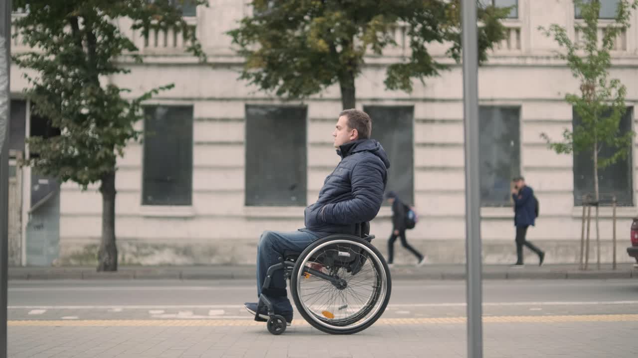 persona con discapacidad física que espera un transporte urbano con una rampa accesible
