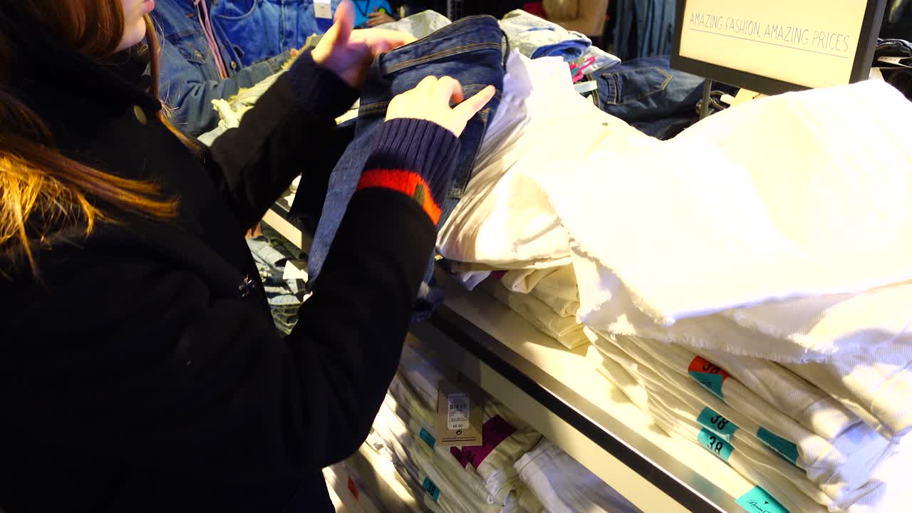 Shopping negli outlet in Europa. La ragazza sceglie i vestiti. Saldi e sconti