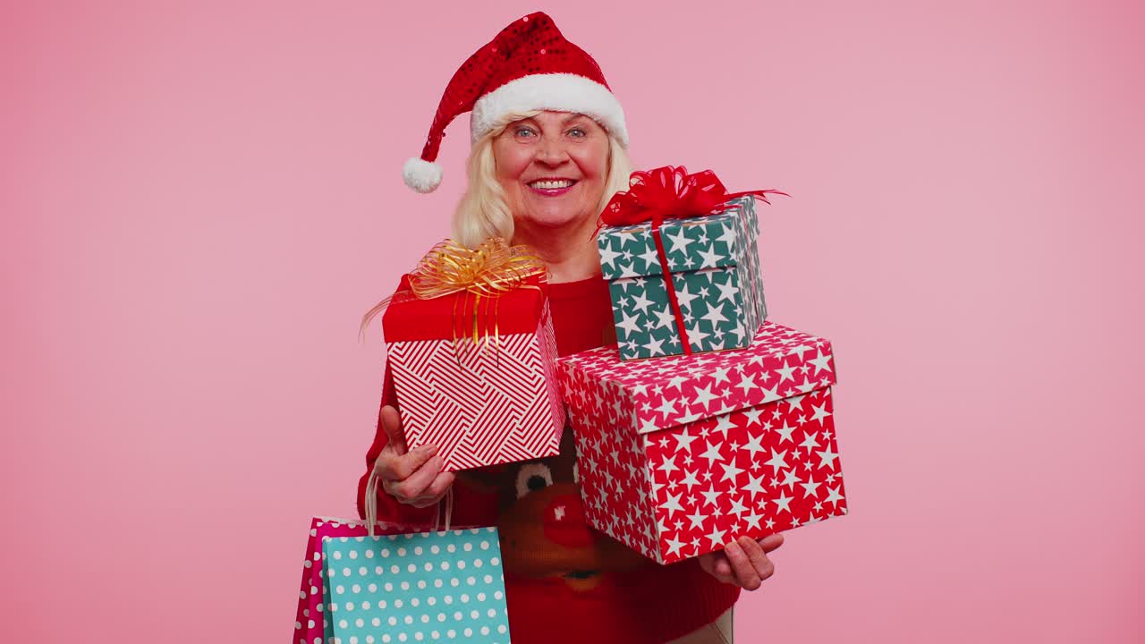 은 할머니는 선물 상자를 들고 크리스마스 할인을 받습니다.