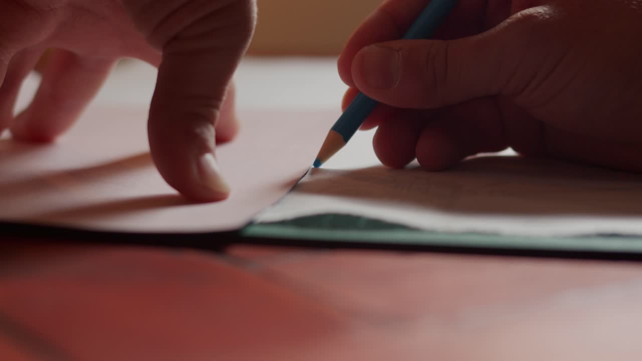 Marking fabric with a blue crayon close up and slow motion.