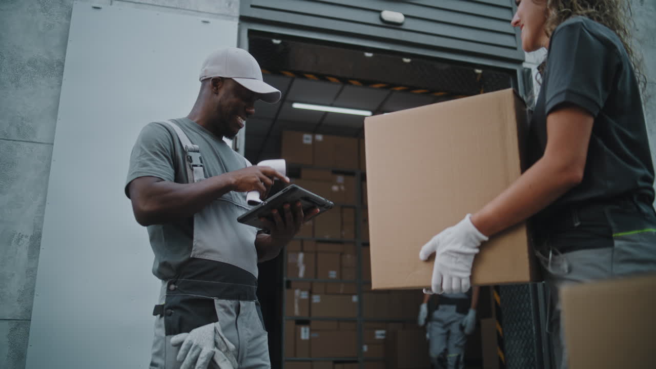 Warehouse Workers Scanning and Moving Packages for Logistics