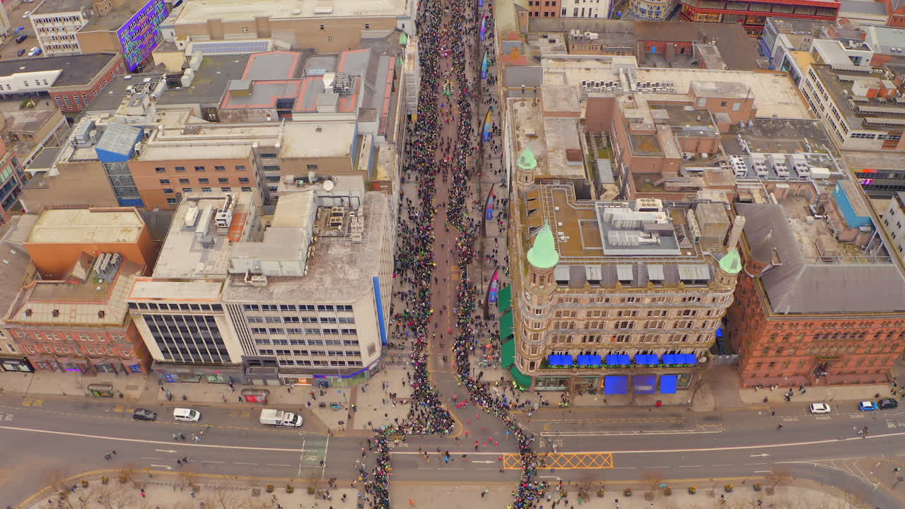 Static aerial view of St. Patrick’s parade crowds filling Belfast city centre street