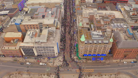 static aerial view of st. patrick’s parade crowds filling belfast city centre street