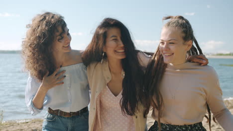 three friends enjoying time together at the riverbank