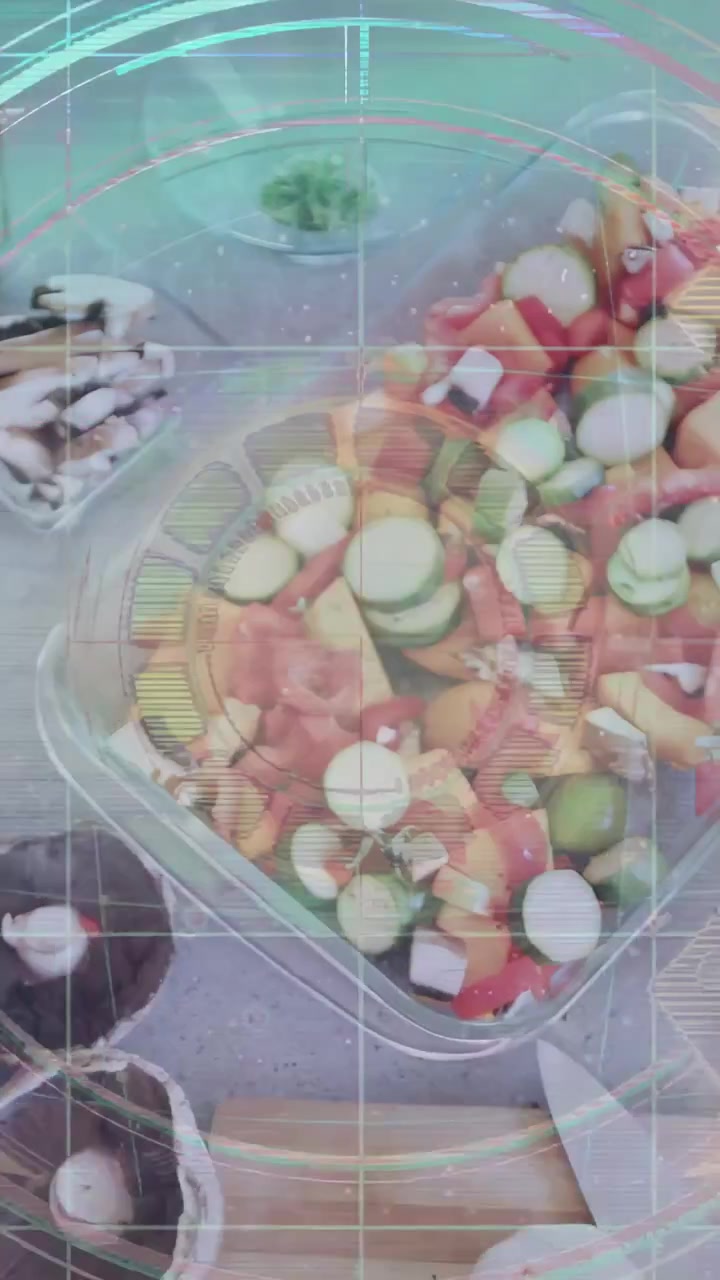 Video verticale: HUD che appare, la telecamera si sposta su un vassoio di verdure tritate, anelli pulsanti evidenziano la preparazione.
