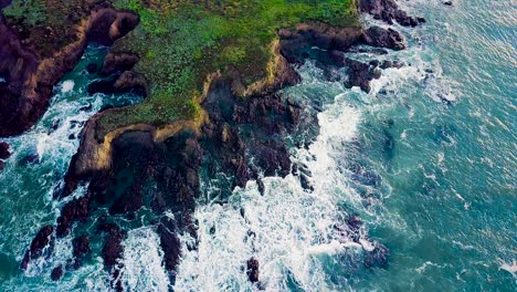 Waves-crash-against-jagged-rocky-point-on-California-coast-at-sunrise