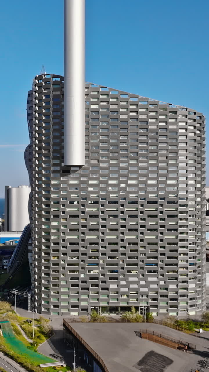 Aerial drone view of CopenHill artificial ski slope on the roof of an energy plant. Vertical