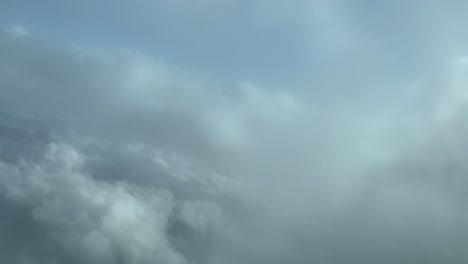 Aerial-clouds-set-view-shot-from-an-airplane-cockpit-while-flying-across-some-fluffy-winter-clods-with-a-deep-blue-sky