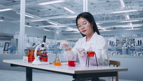 side view of asian woman scientist making experiment with test tube and writing into notebook in the laboratory with microscope. working in the lab analyzing finding sample test tube