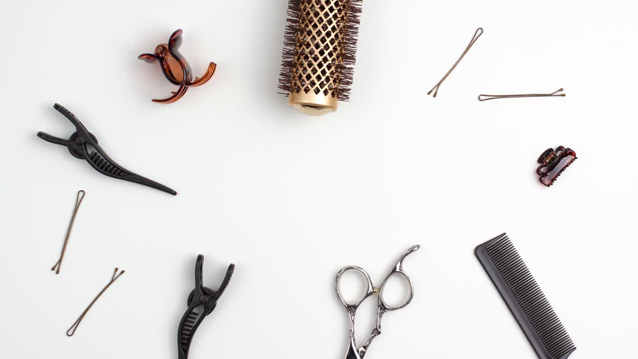 Stop motion animation template flat lay of professional hair cutting shears comb for separating hair hairpins section hair clips and gold round hair brush for styling. Hairdresser salon equipment