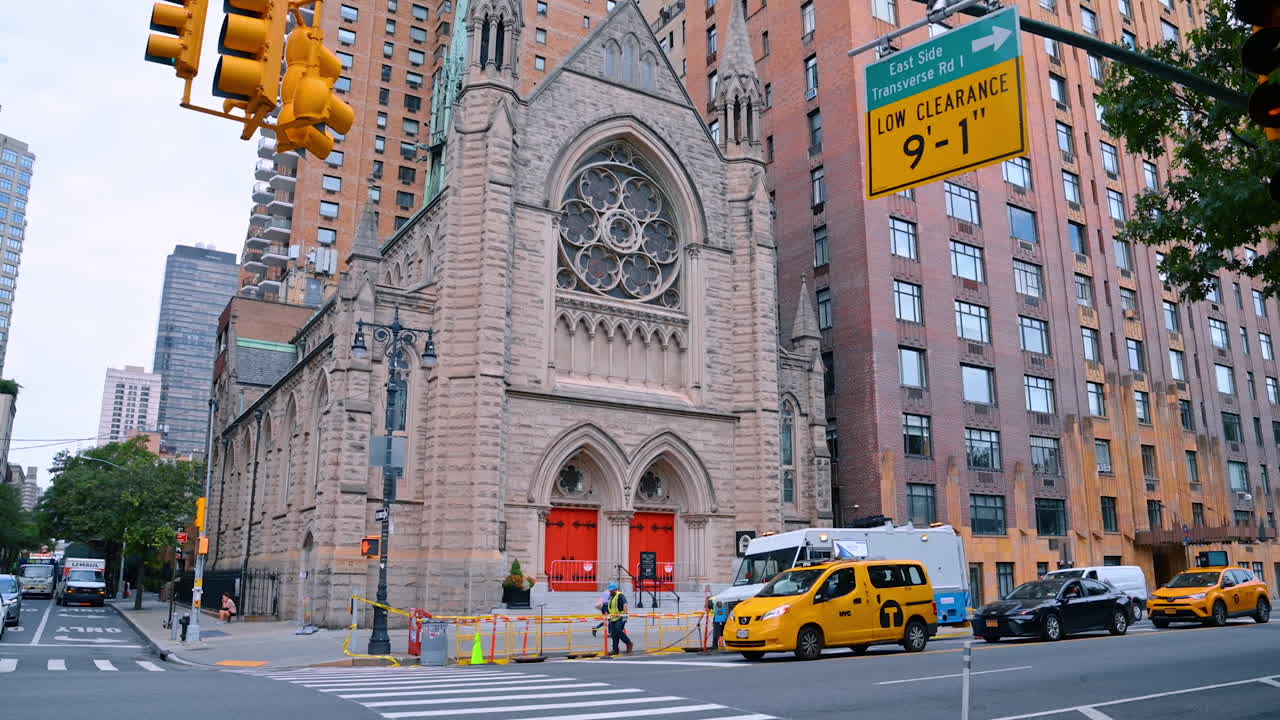 New York, USA, 8 agosto 2025: Attrezzatura di luci gialle stradali sospesa sulle strade di New York, USA. Vista dal basso verso l'alto del bellissimo edificio della Holy Trinity Lutheran Church