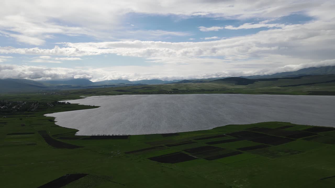초원, 마을, 오래된 집, 산으로 둘러싸인 호수의 공중 촬영