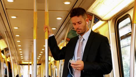 Businessman-using-mobile-phone-while-listening-to-music