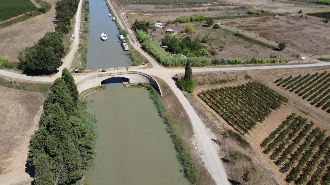Barca che passa sotto un ponte storico sul Canal Du Midi, Sud della Francia.