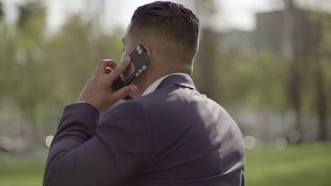 businessman talking by cell phone and running on street