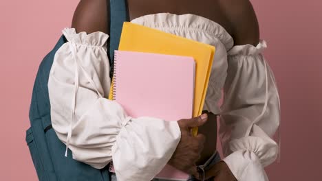 crop black transgender student holding folder and notebook