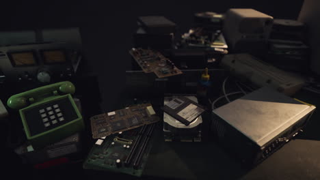 old electronic components and devices scattered on a dark workbench