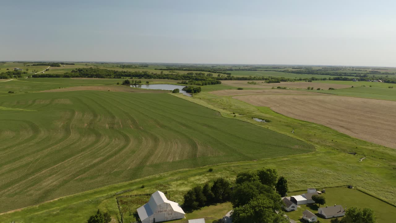 Ripresa aerea panoramica rivela una casa colonica su ampi campi agricoli nelle zone rurali degli Stati Uniti.